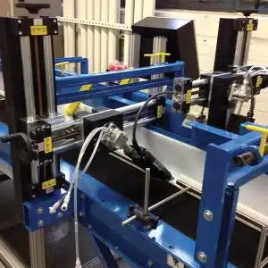 En specialkonstruerad plattform för industriell automatisering med flera verktygshuvuden, positioneringsutrustning och integrerade styrsystem inbyggda i ett ramverk av blått stål.