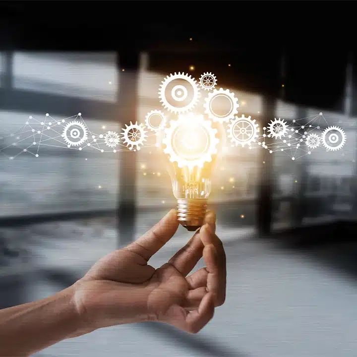 Konceptbild som illustrerar innovation inom tillverkningsindustrin, med en lysande glödlampa och sammankopplade kugghjul som symboliserar teknik och problemlösning.