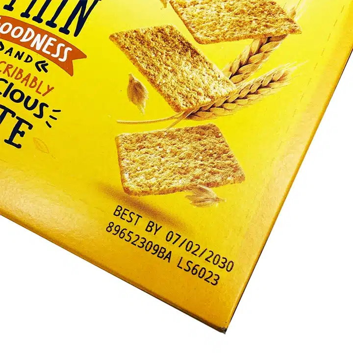 Bäst före-datum och partinummer tryckta på en livsmedelsförpackning av kartong för att möjliggöra spårbarhet av produkten.