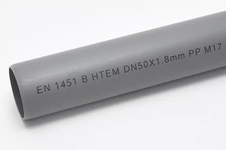 Bläckstråle -tryckt identifieringskod på ett grått PVC-rör för produktspårbarhet.
