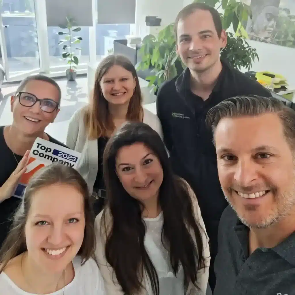 selfie med leende medarbetare som fått företagets främsta utmärkelse