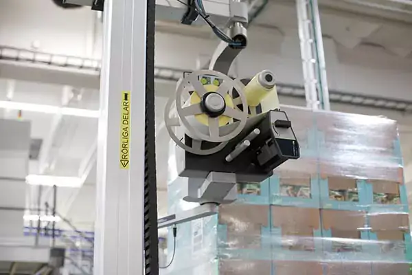 En automatiserad pallmärkningsmaskin i A-serien vid fabriken i Estrella märker inpackade pallar.