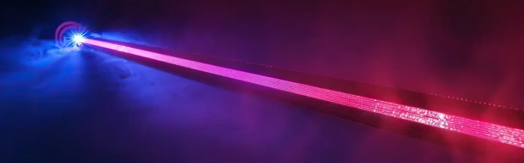 En klarröd laserstråle som sträcker sig över en mörk bakgrund med blå och lila belysning, vilket symboliserar industriell lasermärkningsteknik.
