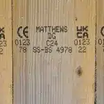 Träskiva med tryckta UKCA- och CE-märkningar, Matthews-identifikationskoder samt ytterligare produktinformation.